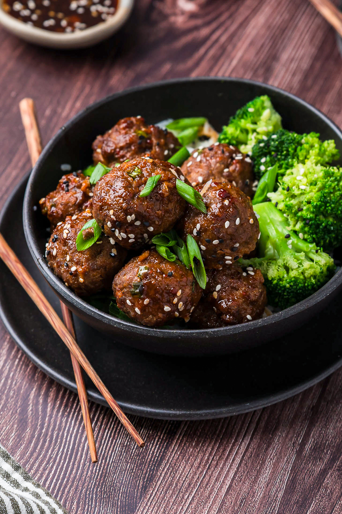 Asian Meatballs served in a black bowl with broccoli