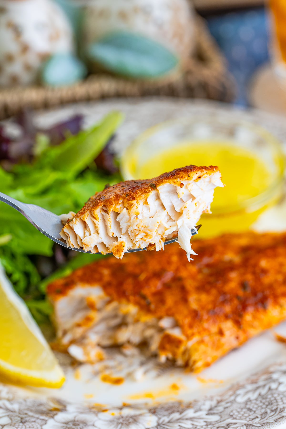 a fork holding up a bite of Baked Mahi Recipe in air