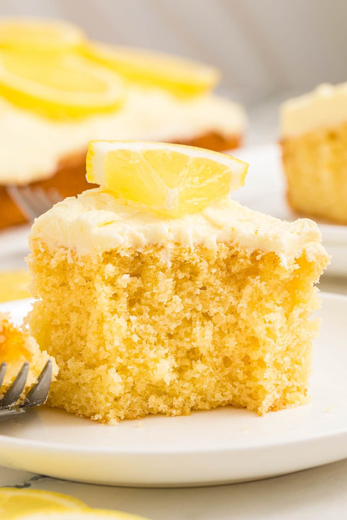 a piece of Lemon Cake on white plate with a bite taken out