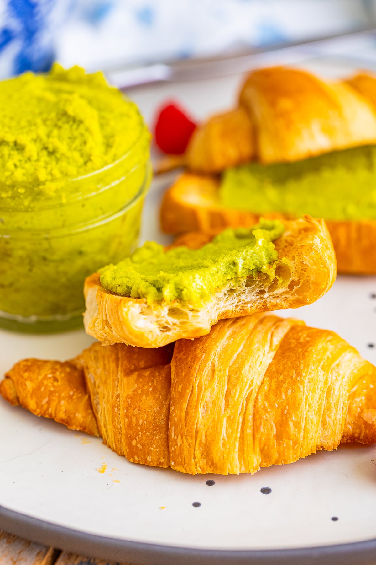 a piece of croissant with a bite taken out topped with Pistachio Spread