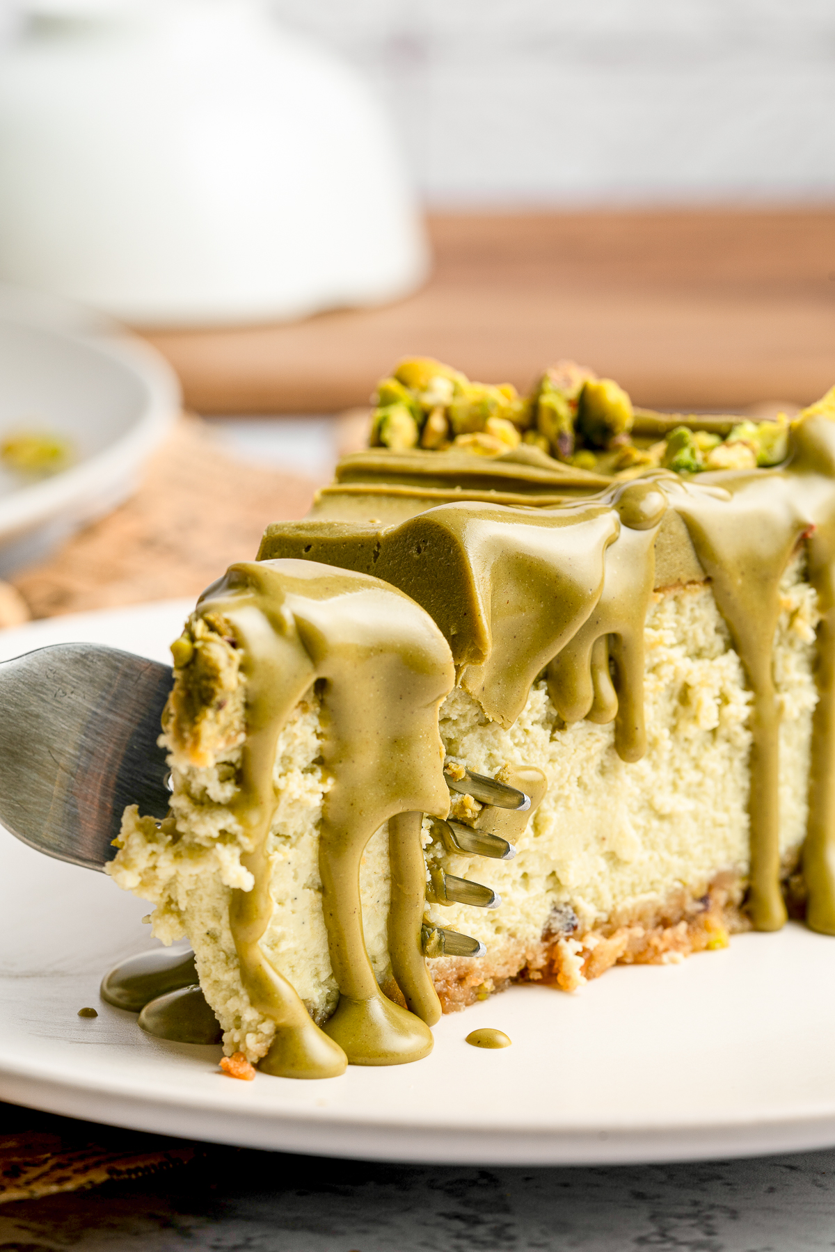 a piece of Pistachio Cheesecake with a fork grabbing a bite