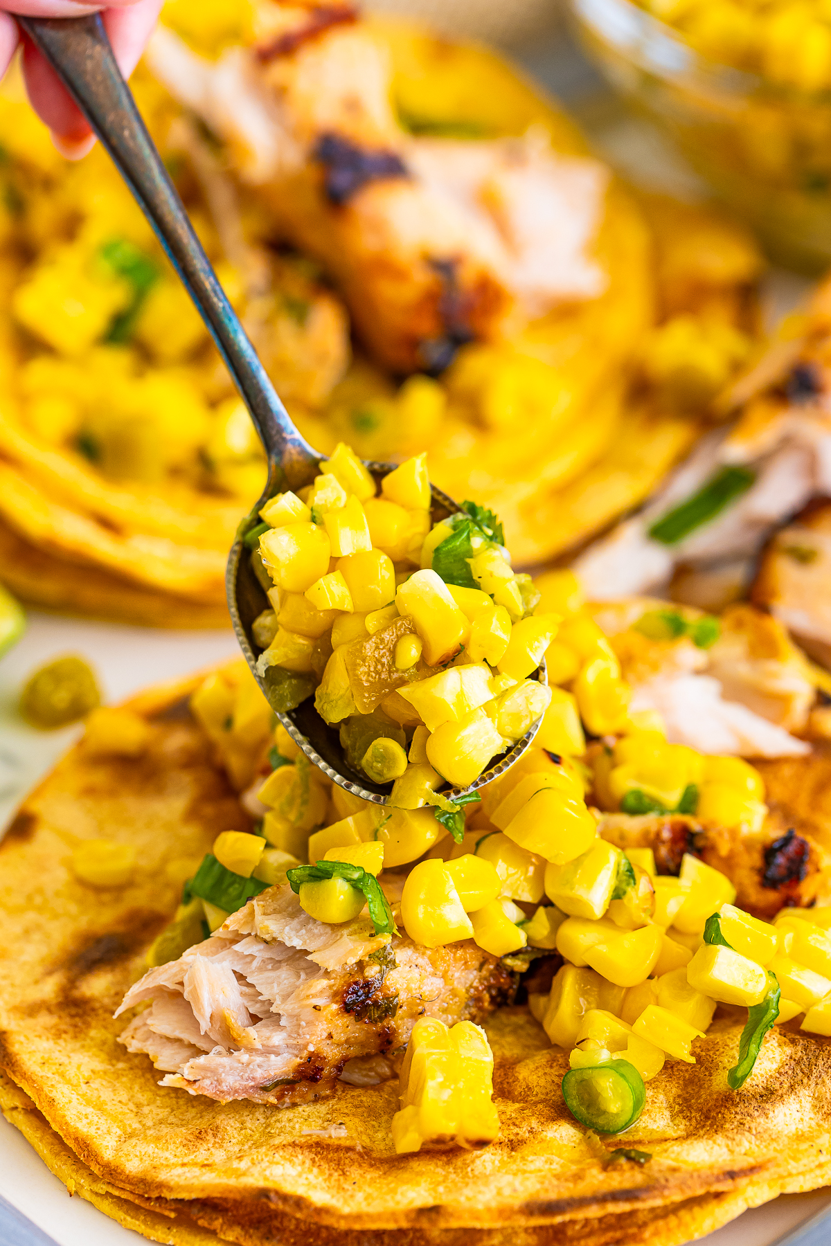 Roasted Corn Salsa being poured on to a taco