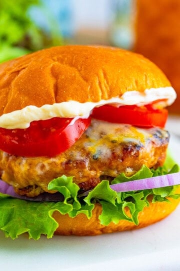 A juicy turkey burger with melted cheese, lettuce, tomato, and onion on a toasted bun
