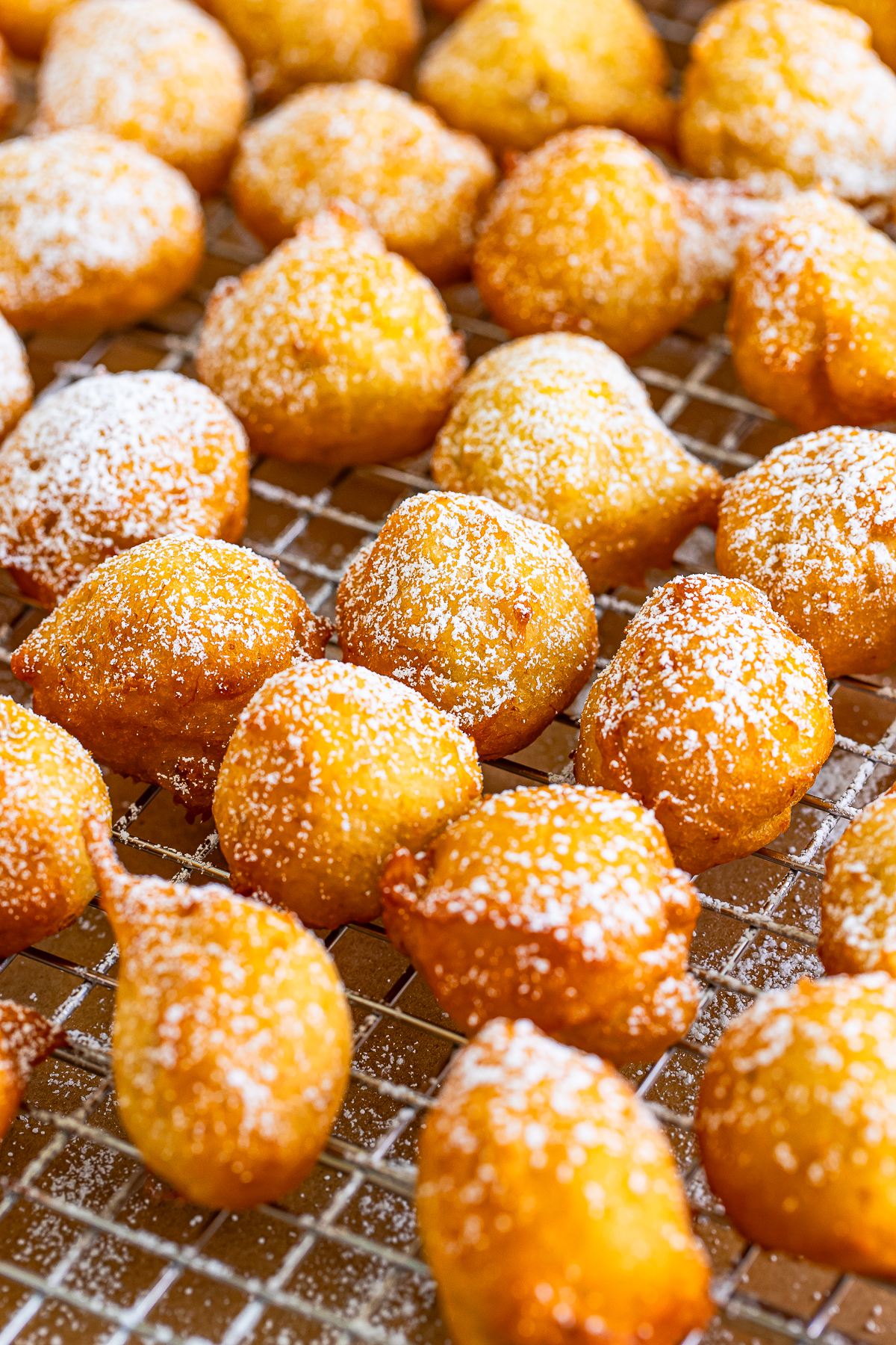 Banana Fritters on a wire rack dusted with powdered sugar