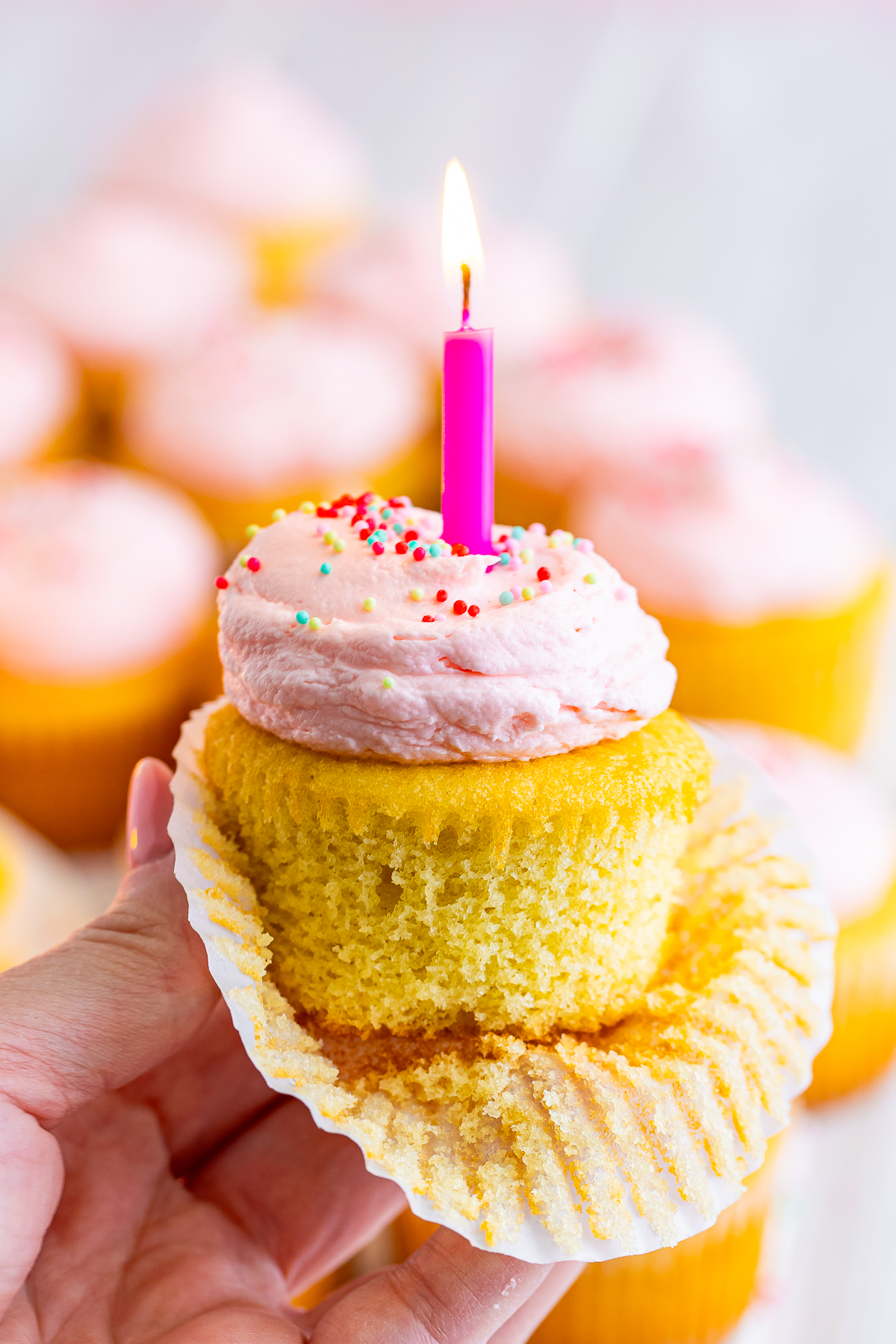 a hand holding up Birthday Cupcakes in air