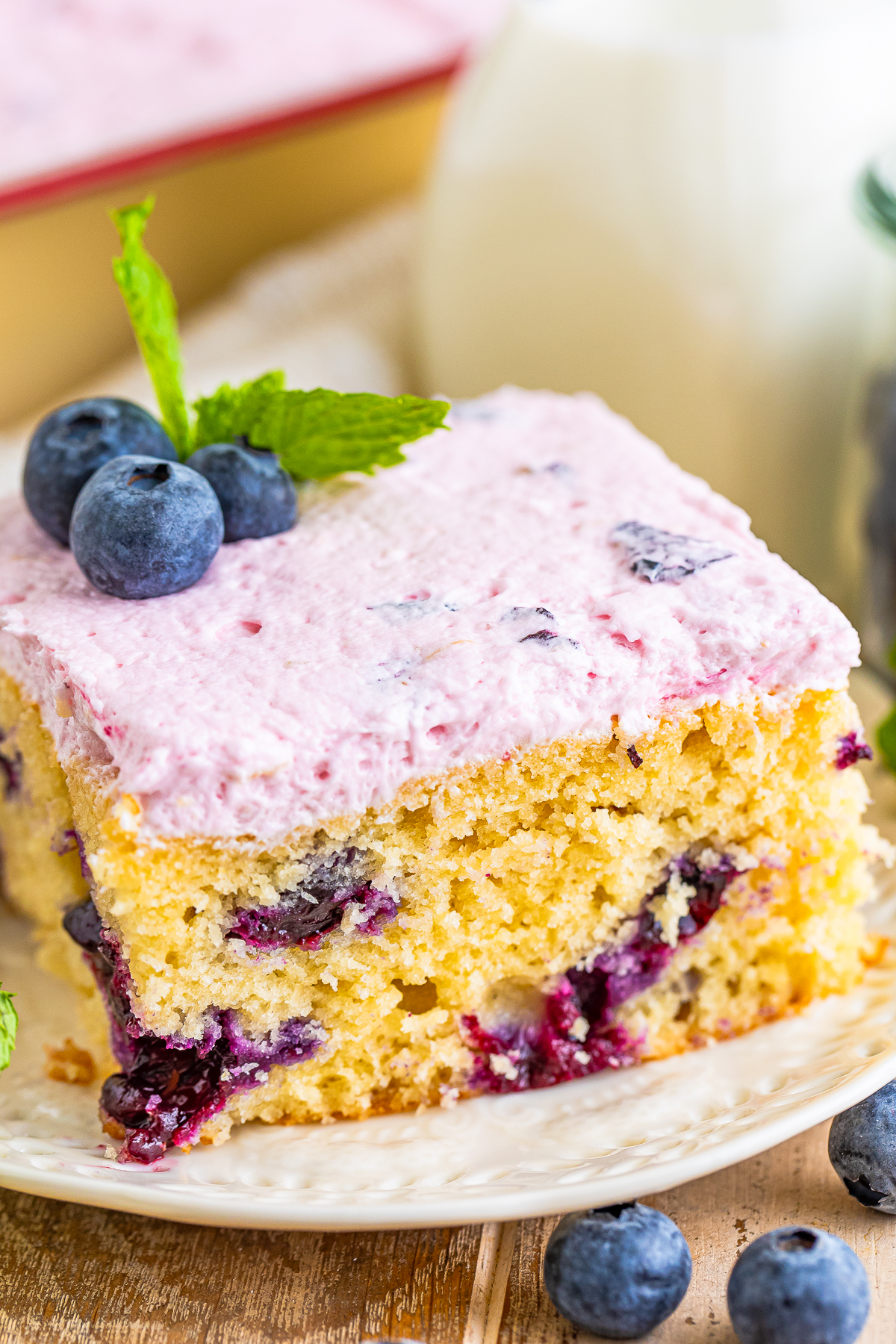 up close slice of Blueberry Cake on a ivory plate