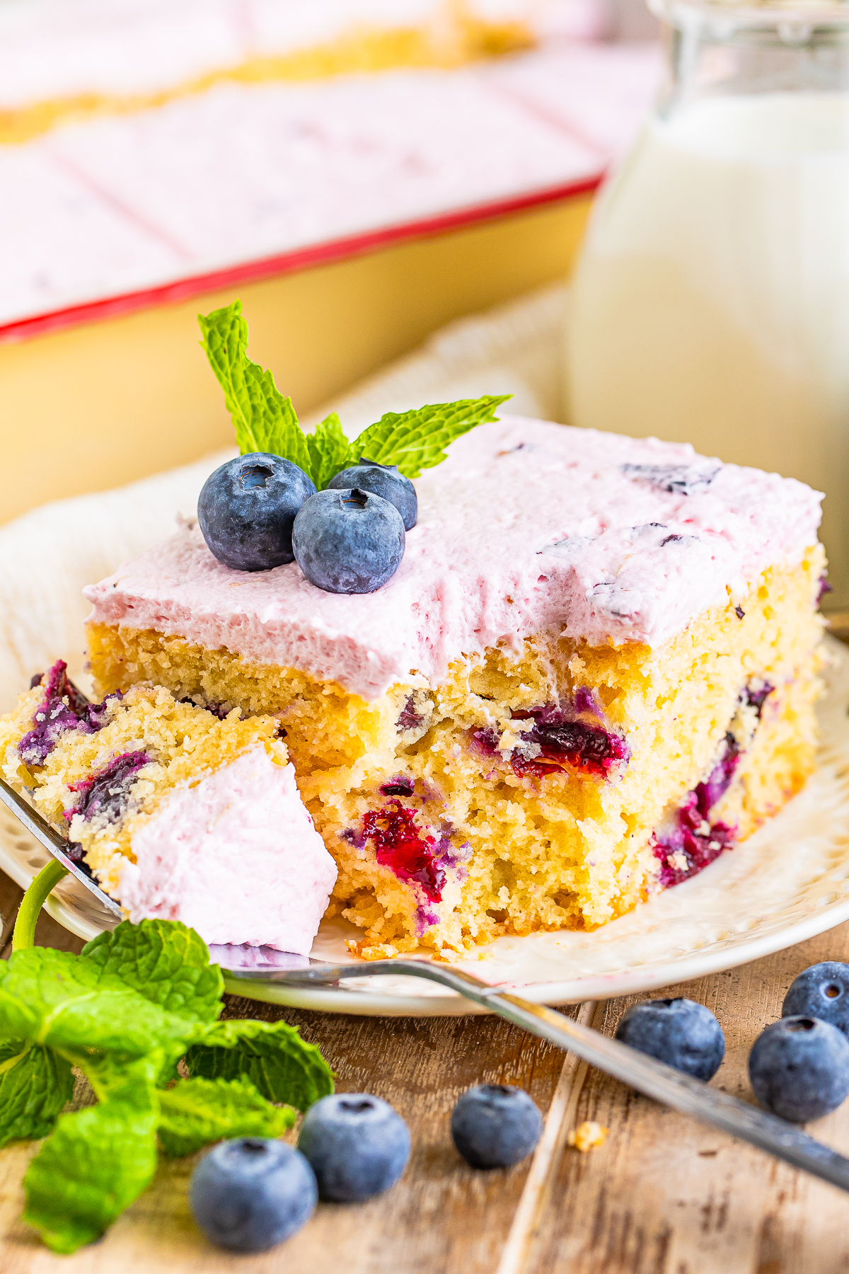 a piece of Blueberry Cake on a plate with a bite taken out
