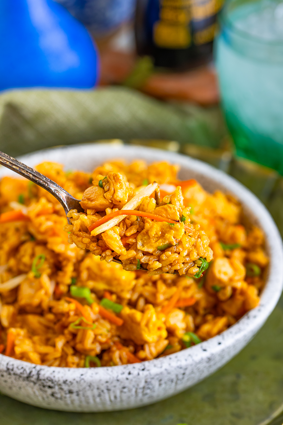 a spoon holding up a bite of Chicken Fried Rice in air