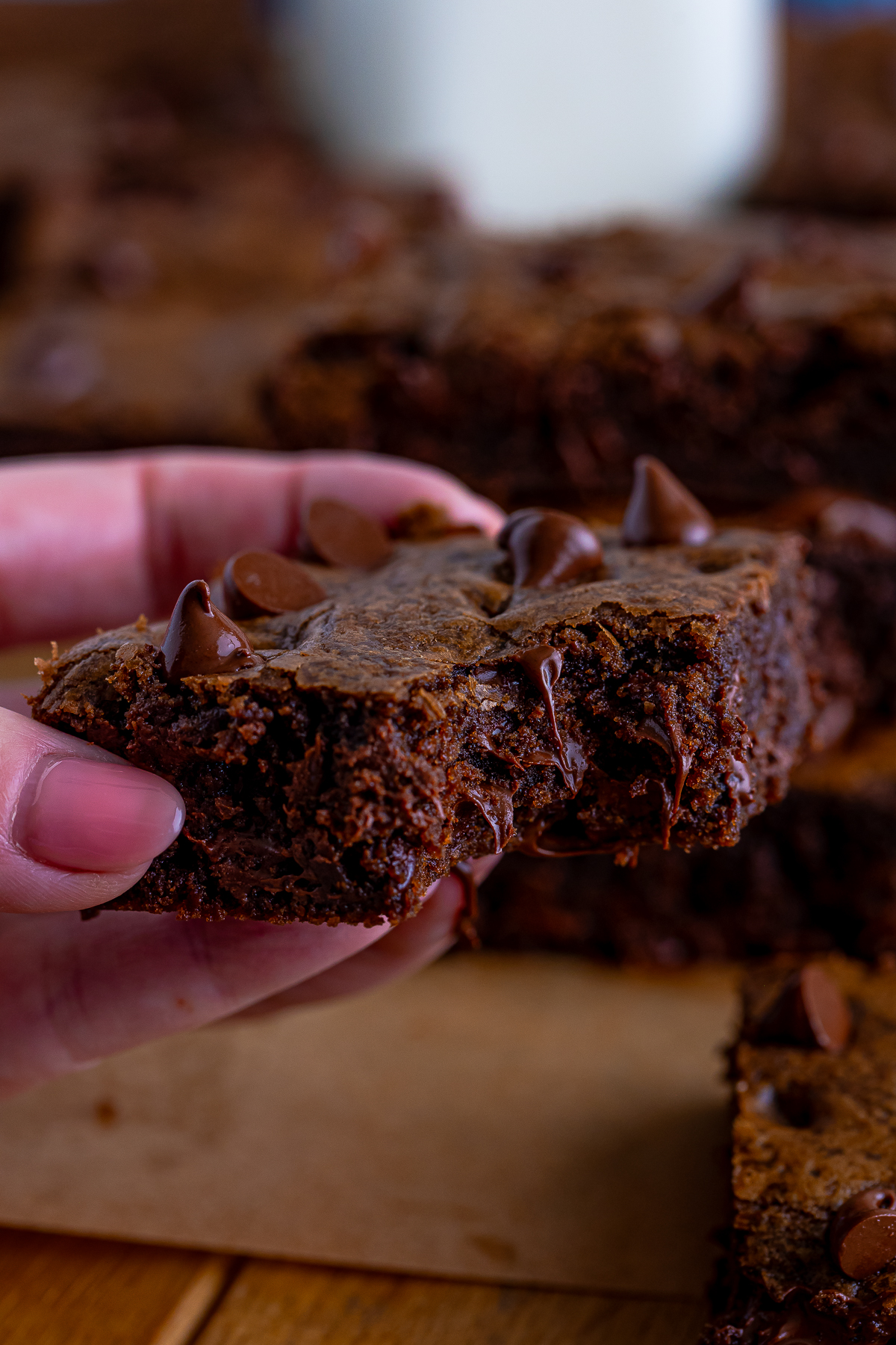 a hand holding up Chocolate Cookie Bars in air with a bite taken out