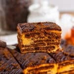 A slice of chocotorta showing layers of chocolate cookies, dulce de leche cream, and ganache.