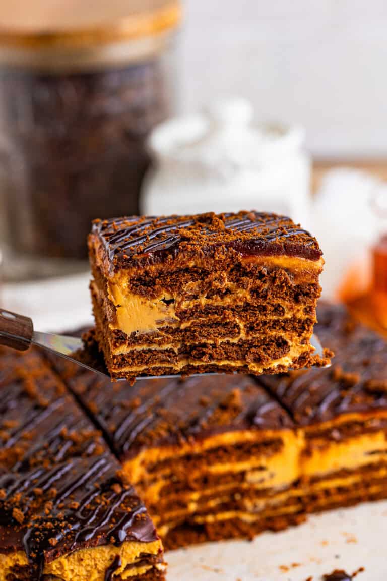 A slice of chocotorta showing layers of chocolate cookies, dulce de leche cream, and ganache.