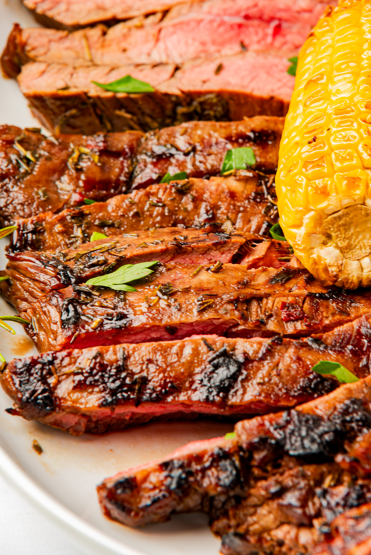 up close image of finished steak on a plate with Flank Steak Marinade