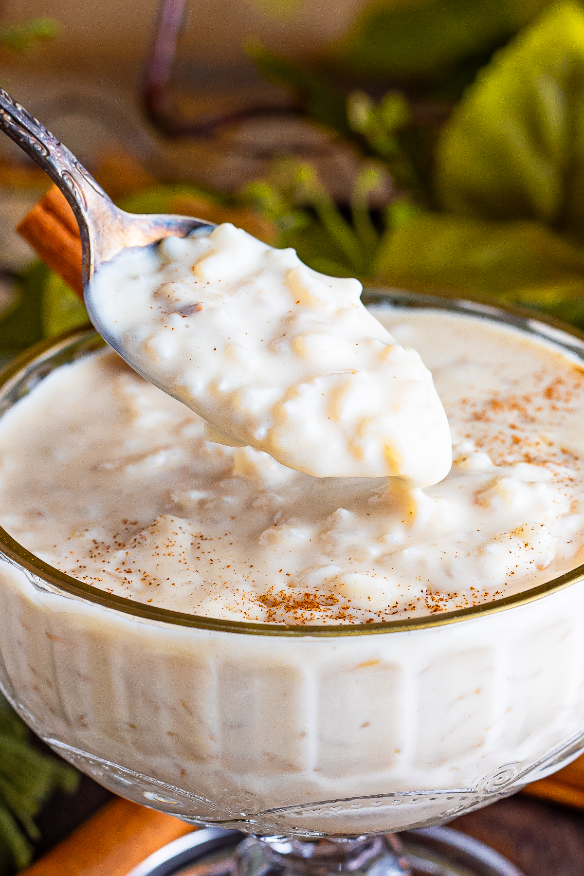 a spoon holding up a bite of Mexican Rice Pudding over the bowl in air