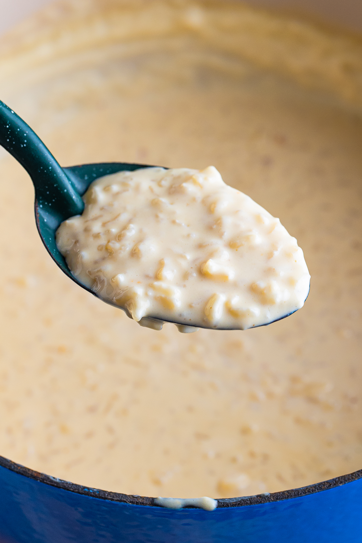 a spoon holding up a portion of Mexican Rice Pudding in air