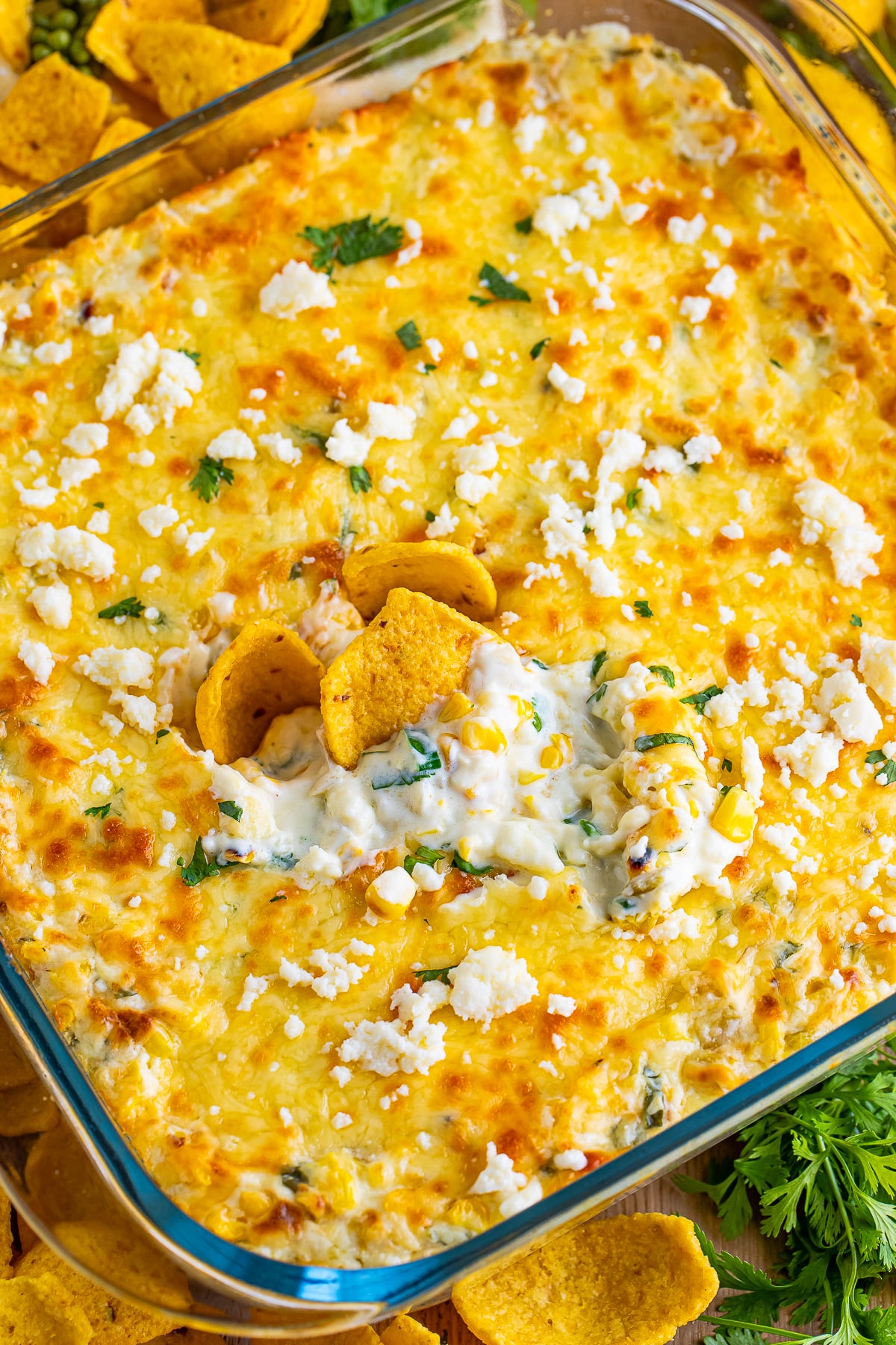 overhead image of Mexican Street Corn dip in a baking dish with corn chips in it