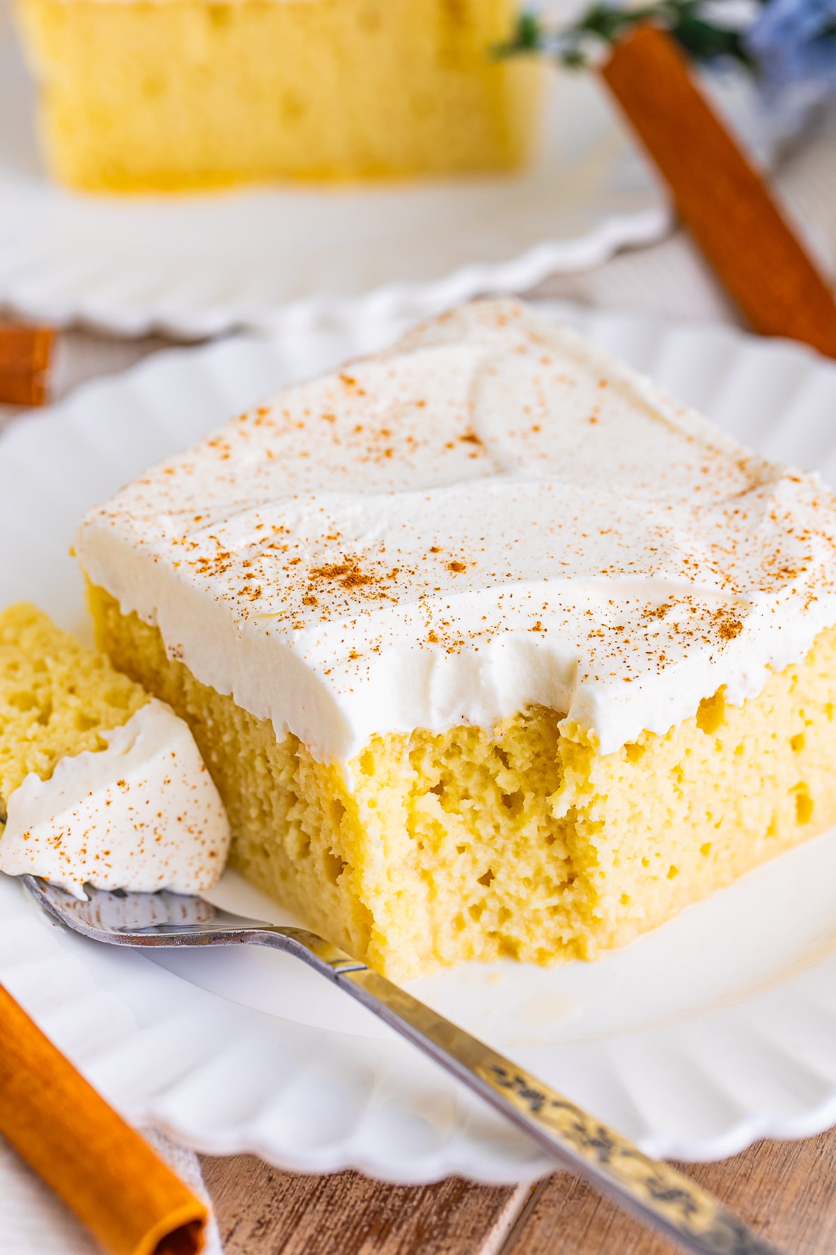 a bite taken out of a piece of Mexican Tres Leches Cake Recipe on a white plate