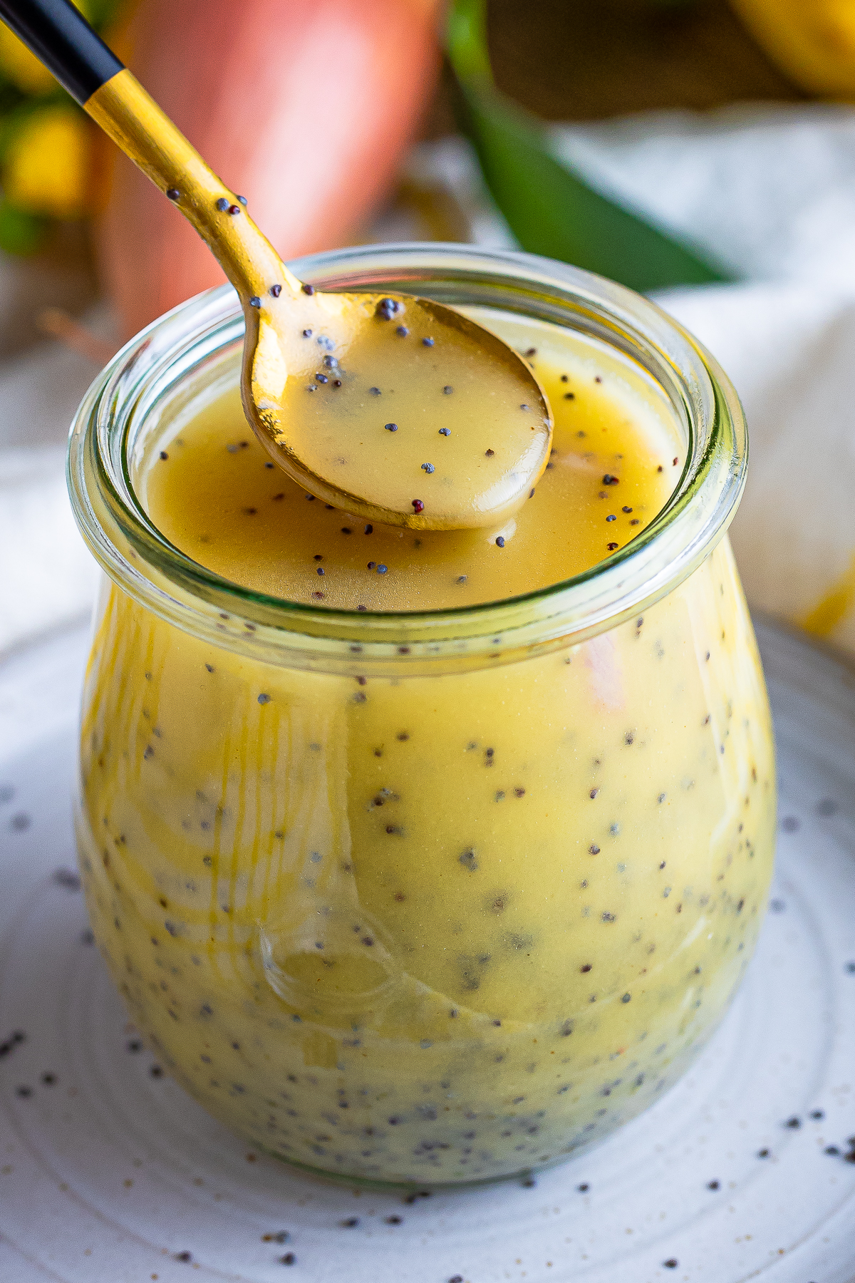 a spoon pouring Poppy Seed Dressing back in the jar