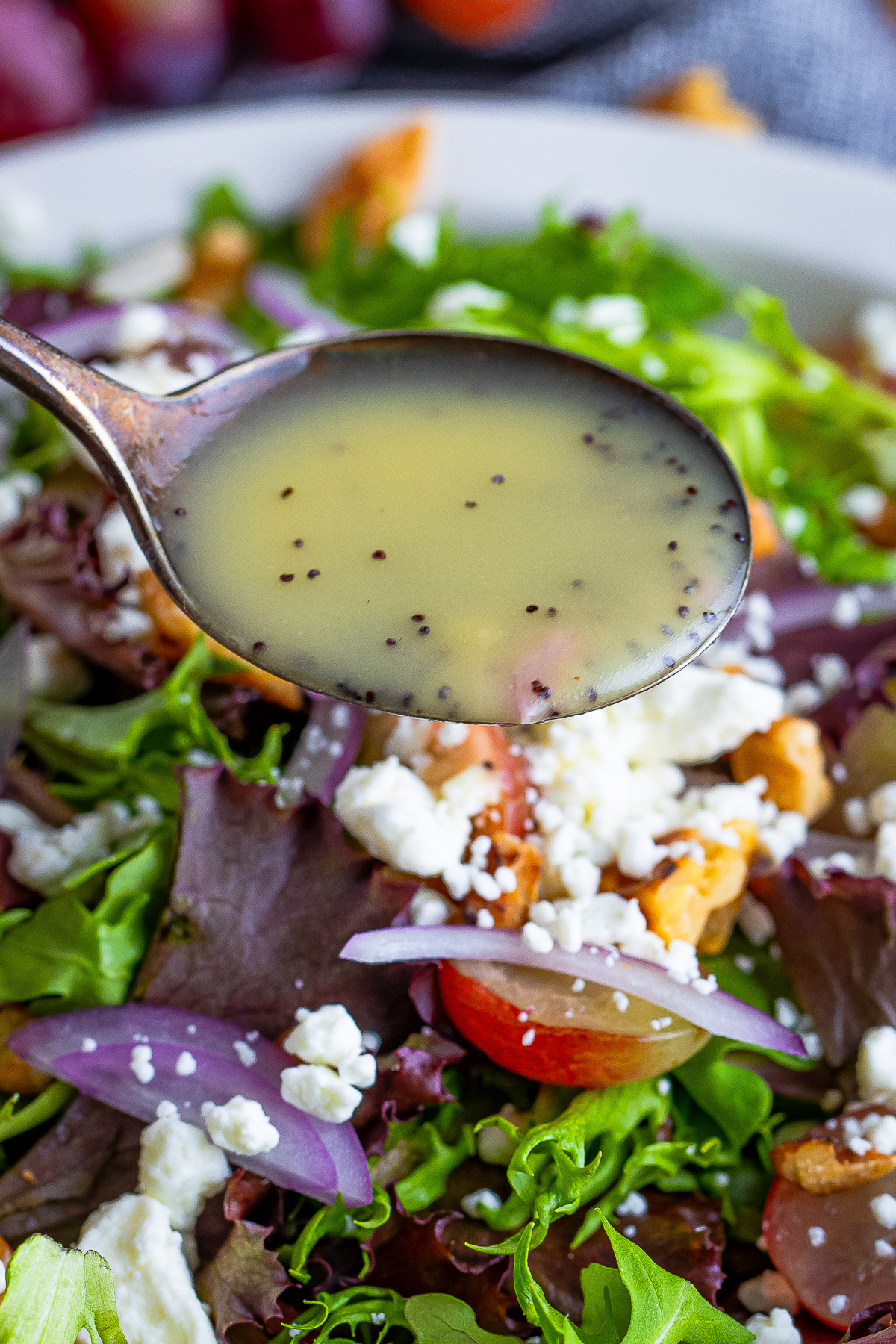 a spoon pouring Poppy Seed Dressing over a salad