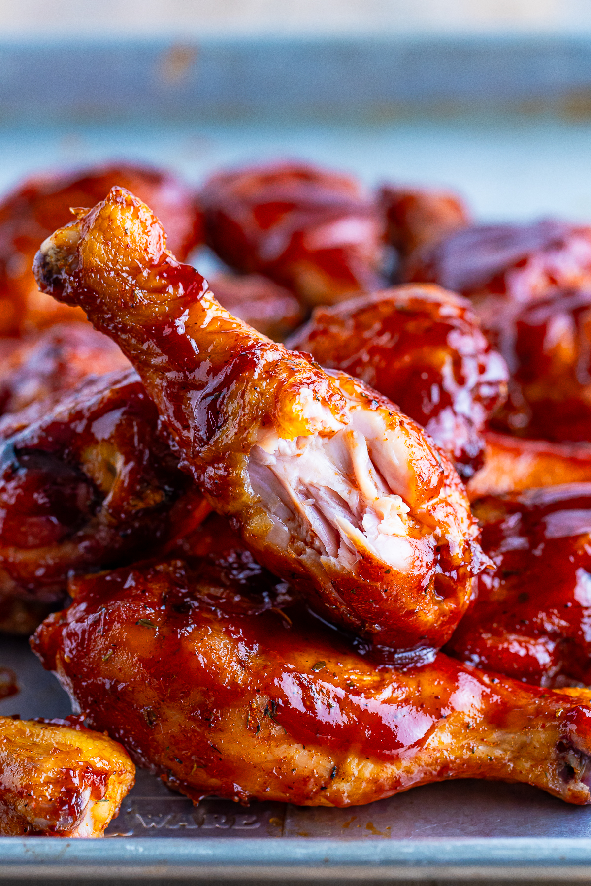 Smoked Chicken Legs on a tray the one on top has a bite taken out