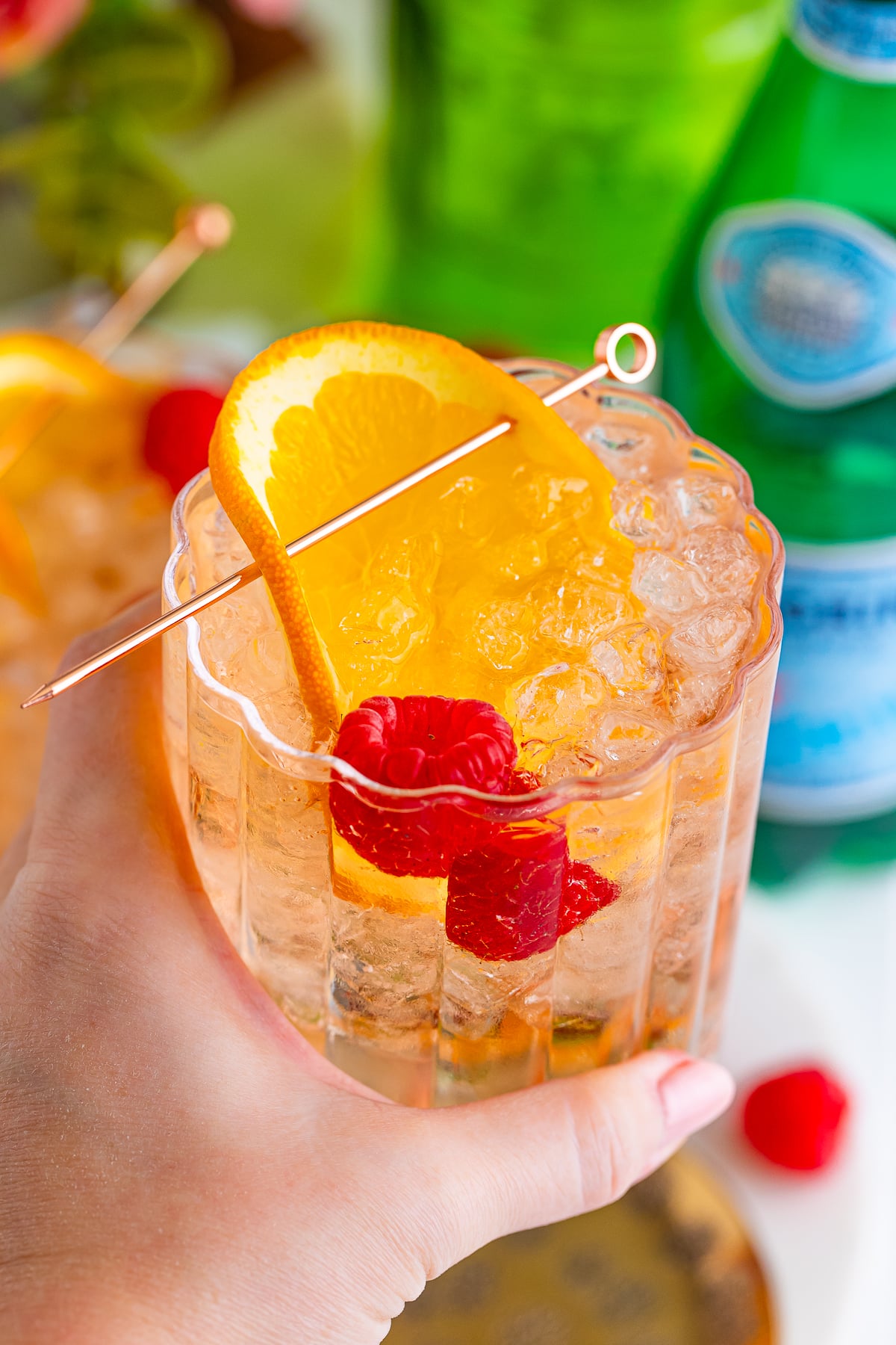 a hand holding up a Spritzer in air