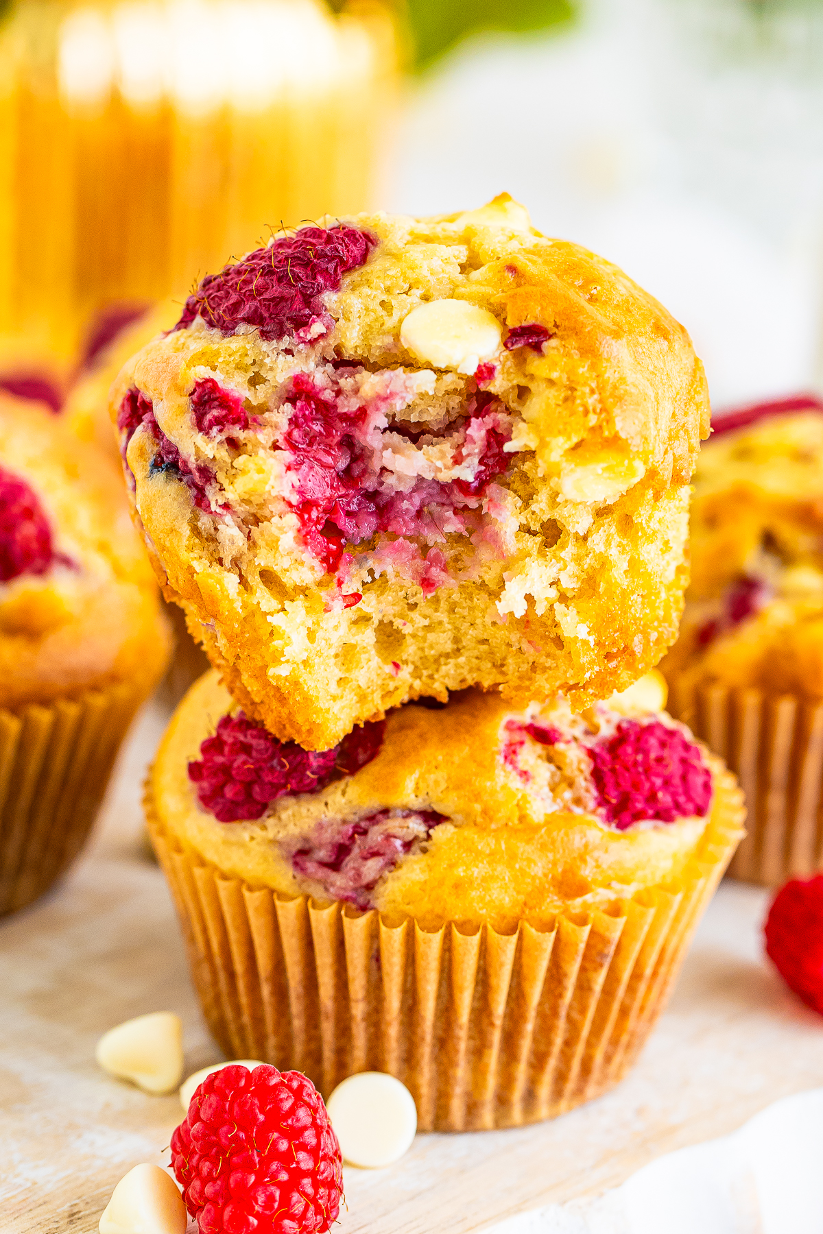 two White Chocolate and Raspberry Muffins stacked with a bite taken out