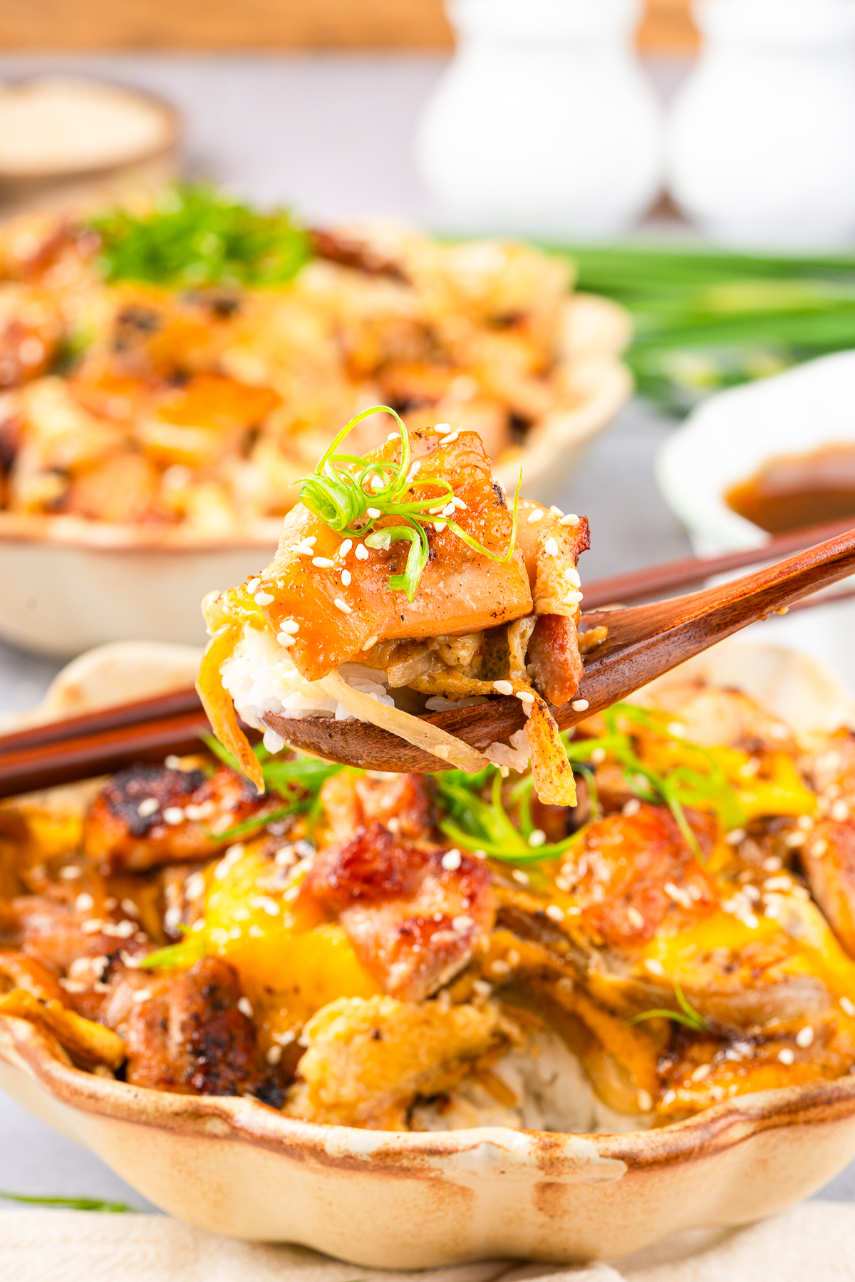 a spoon holding up a bite of Oyakodon in air