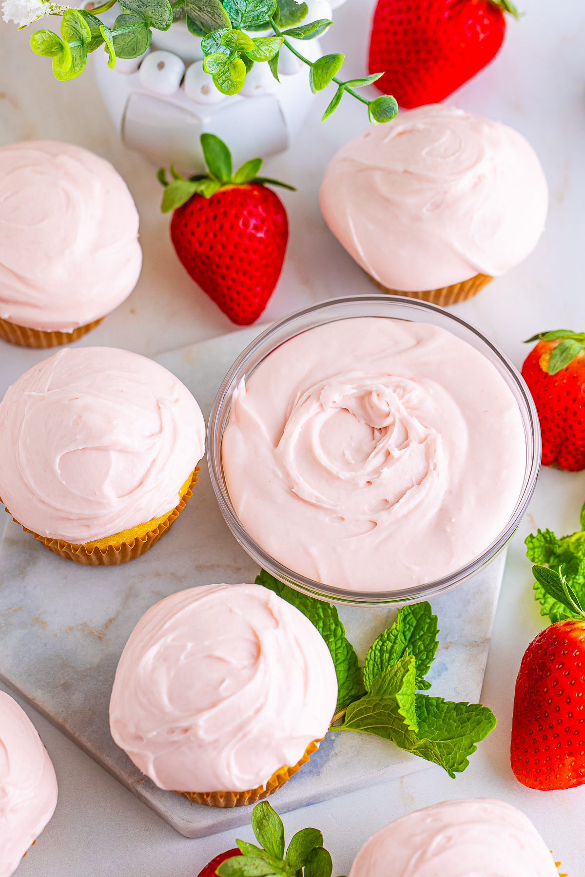 overhead image of Strawberry Cream Cheese Frosting in a bowl and on cupcakes