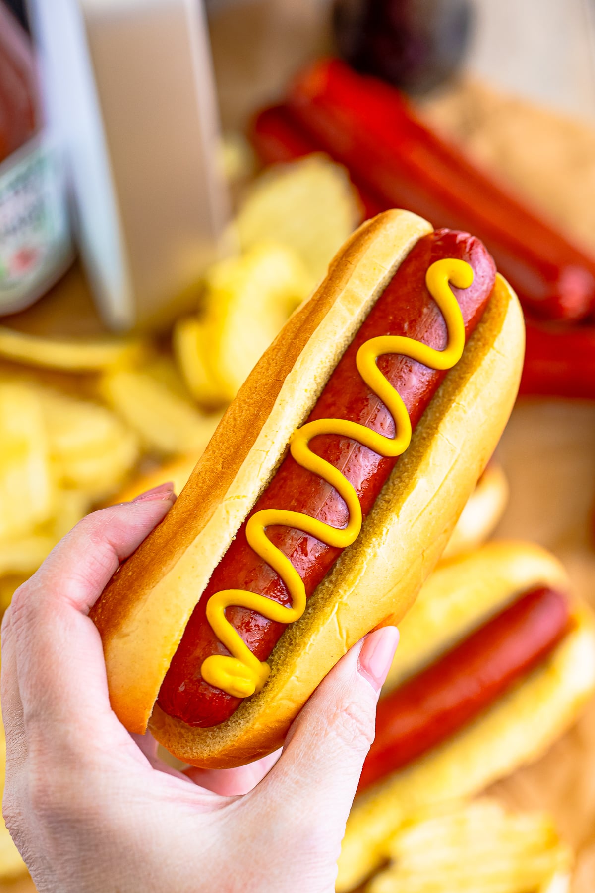 a hand holding up Air Fry Hot Dogs in air