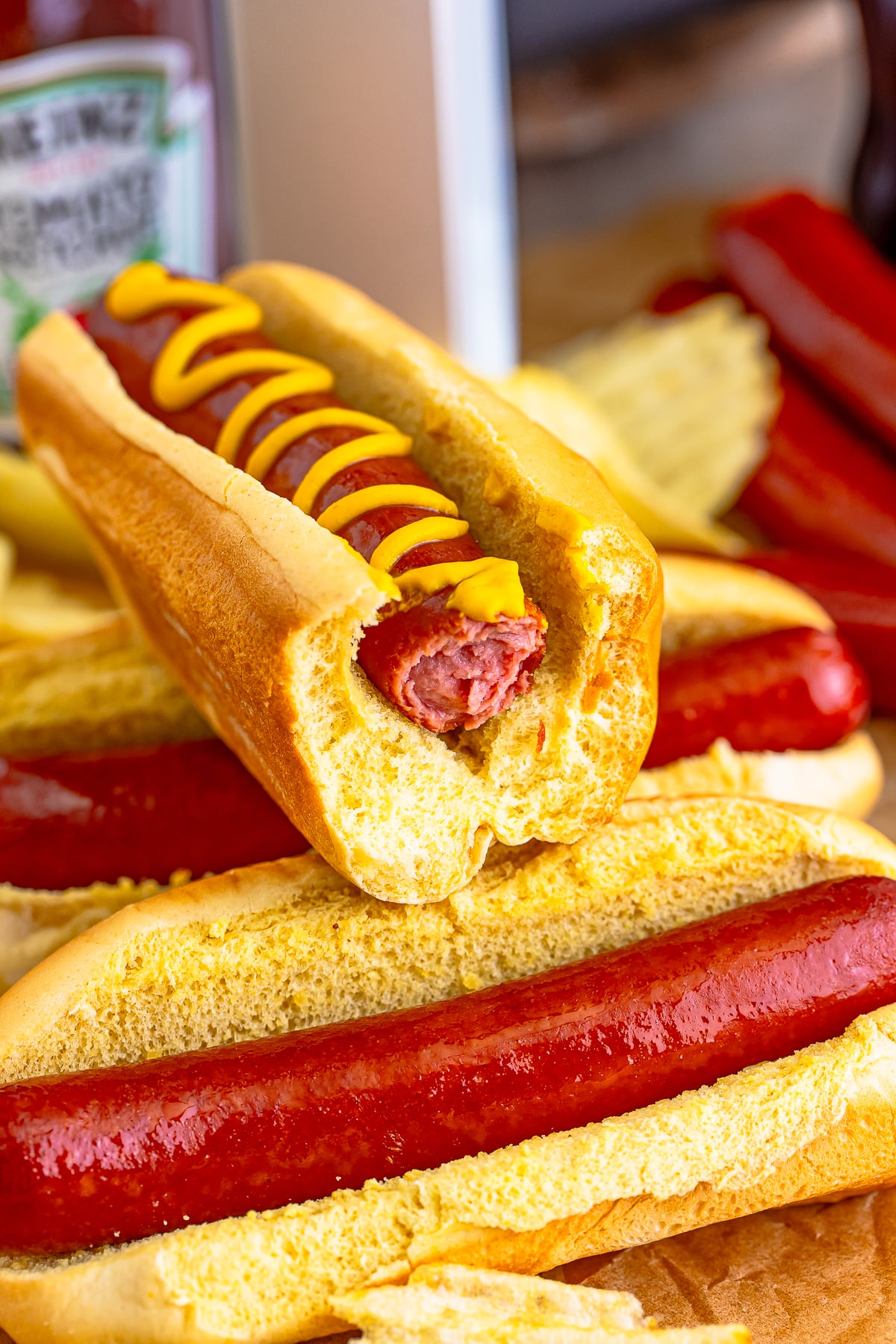 Air Fry Hot Dogs with a bite taken out stacked on more hot dogs