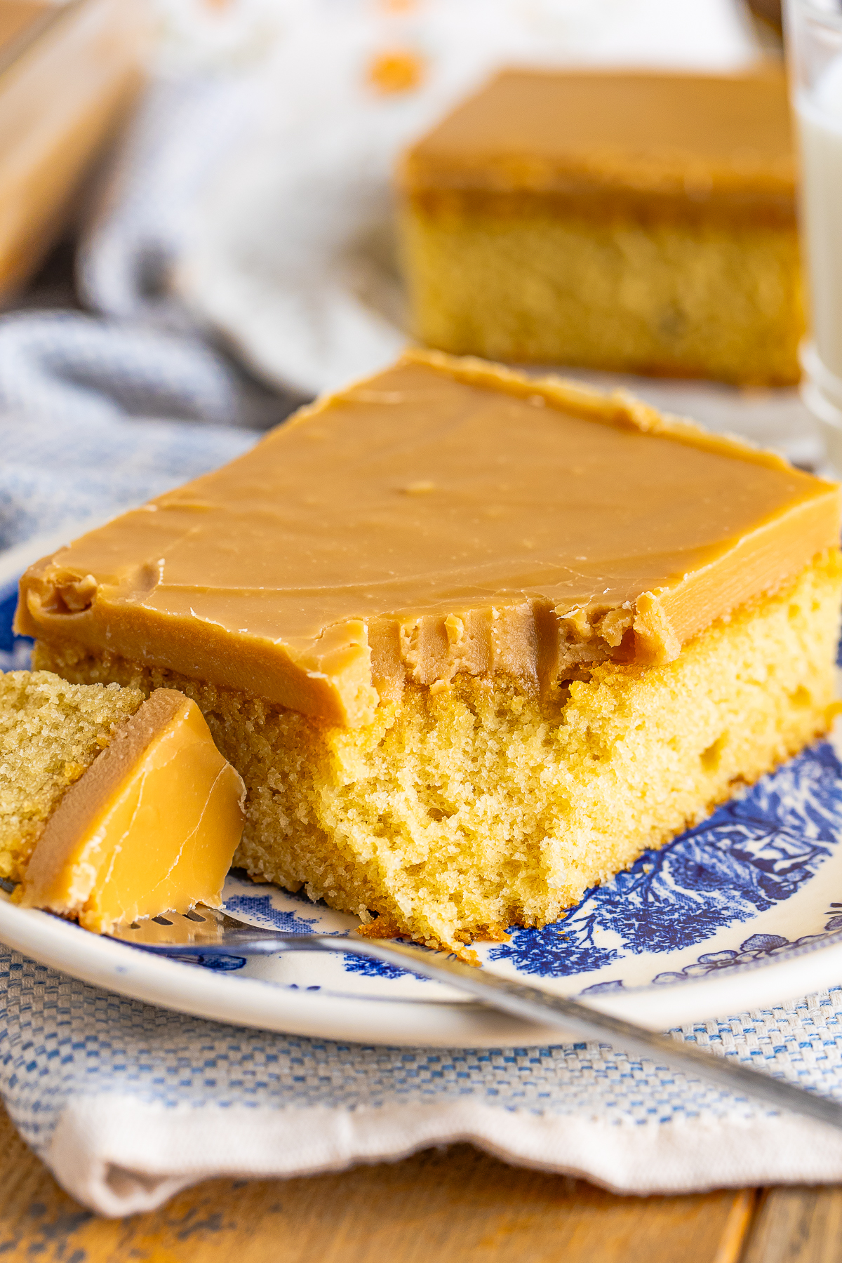 a slice of Caramel Cake on a plate with a bite taken out