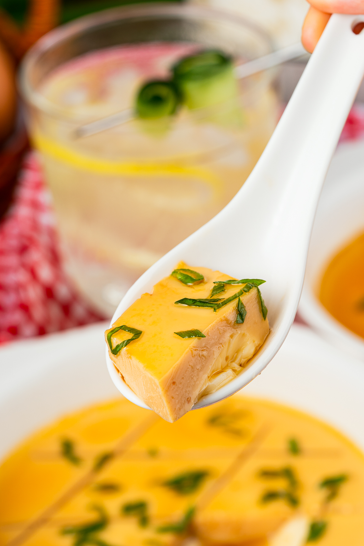a spoon holding up a bite of Chinese Steamed Eggs Recipe in air