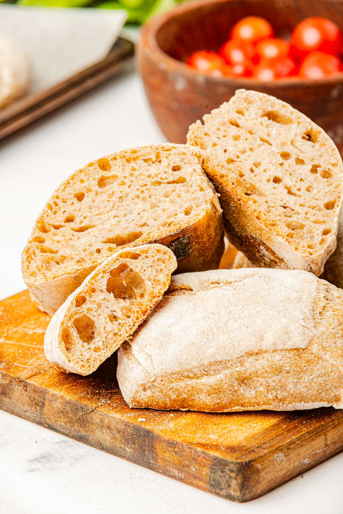 Ciabatta Bread Rolls on a wooden board, some cut in half