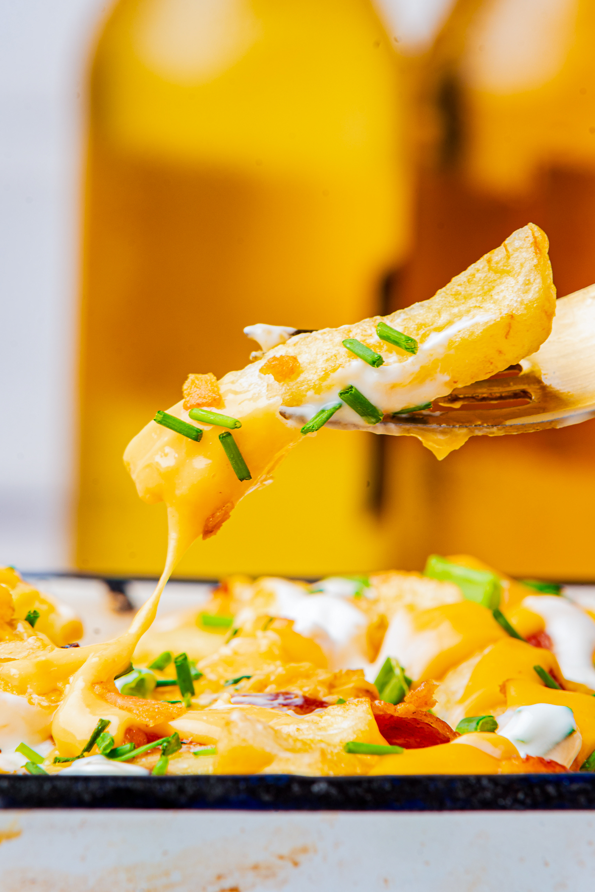 a fork holding up Loaded French Fries in the air