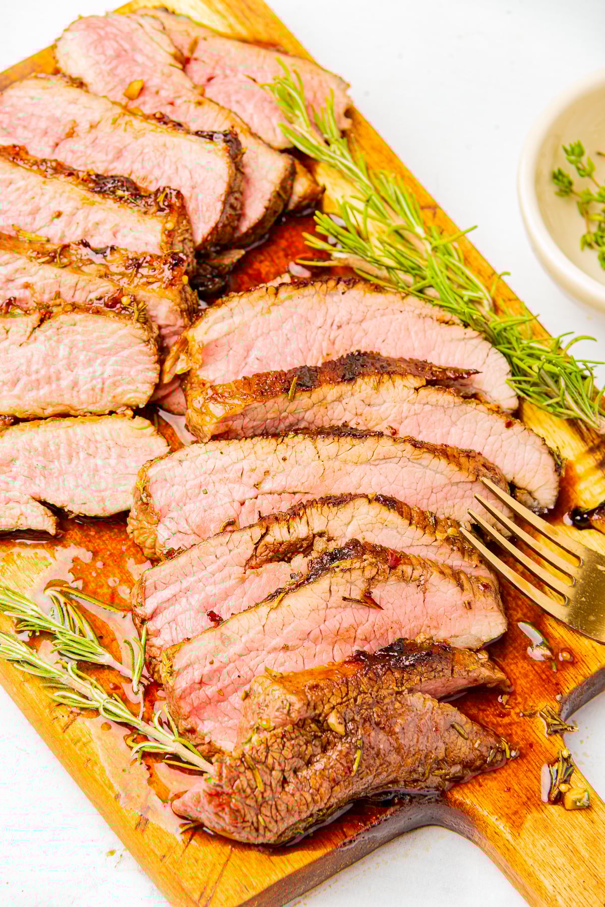 overhead image of sliced steak on a wooden board using London Broil Marinade