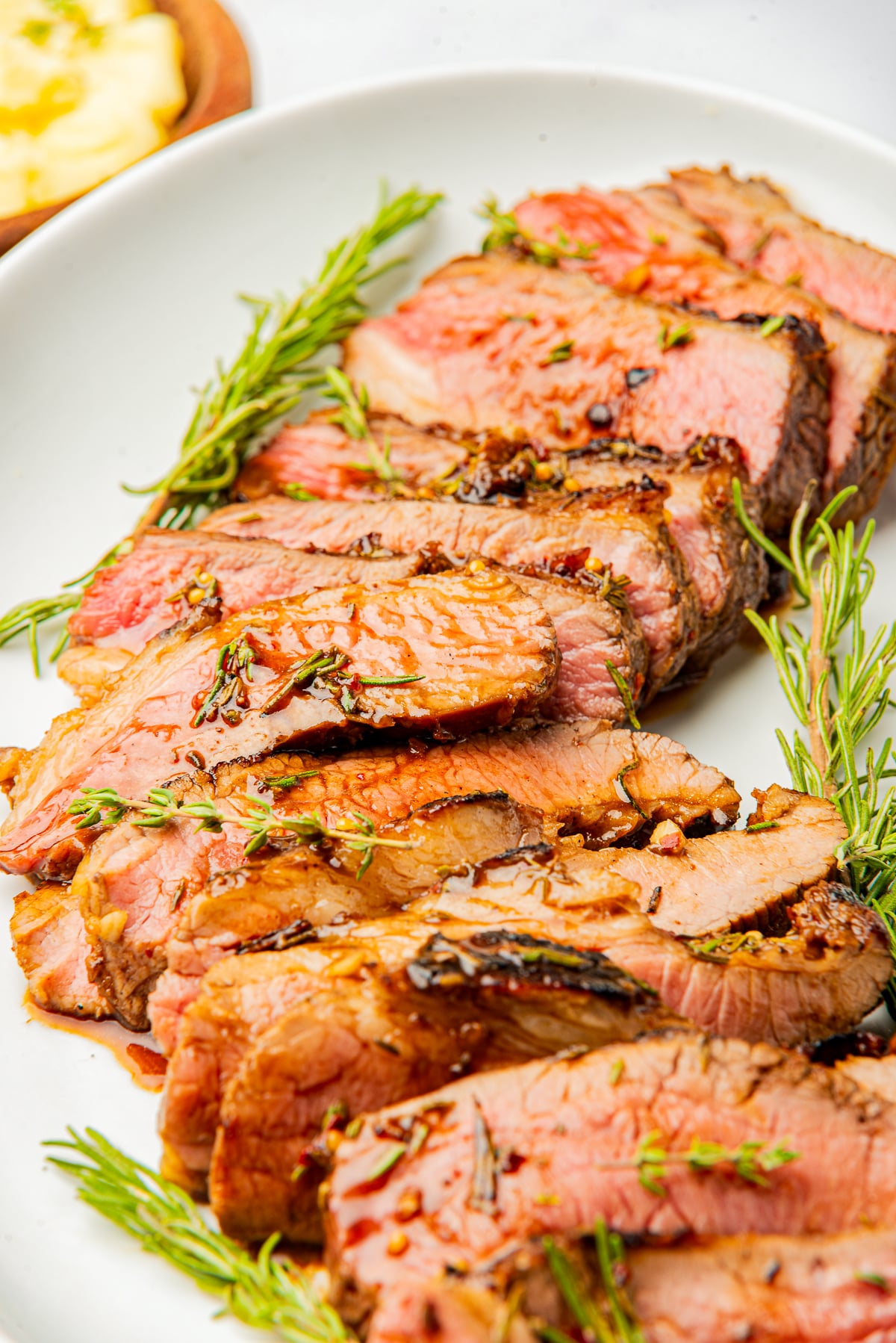 sliced steak on a serving plate using London Broil Marinade