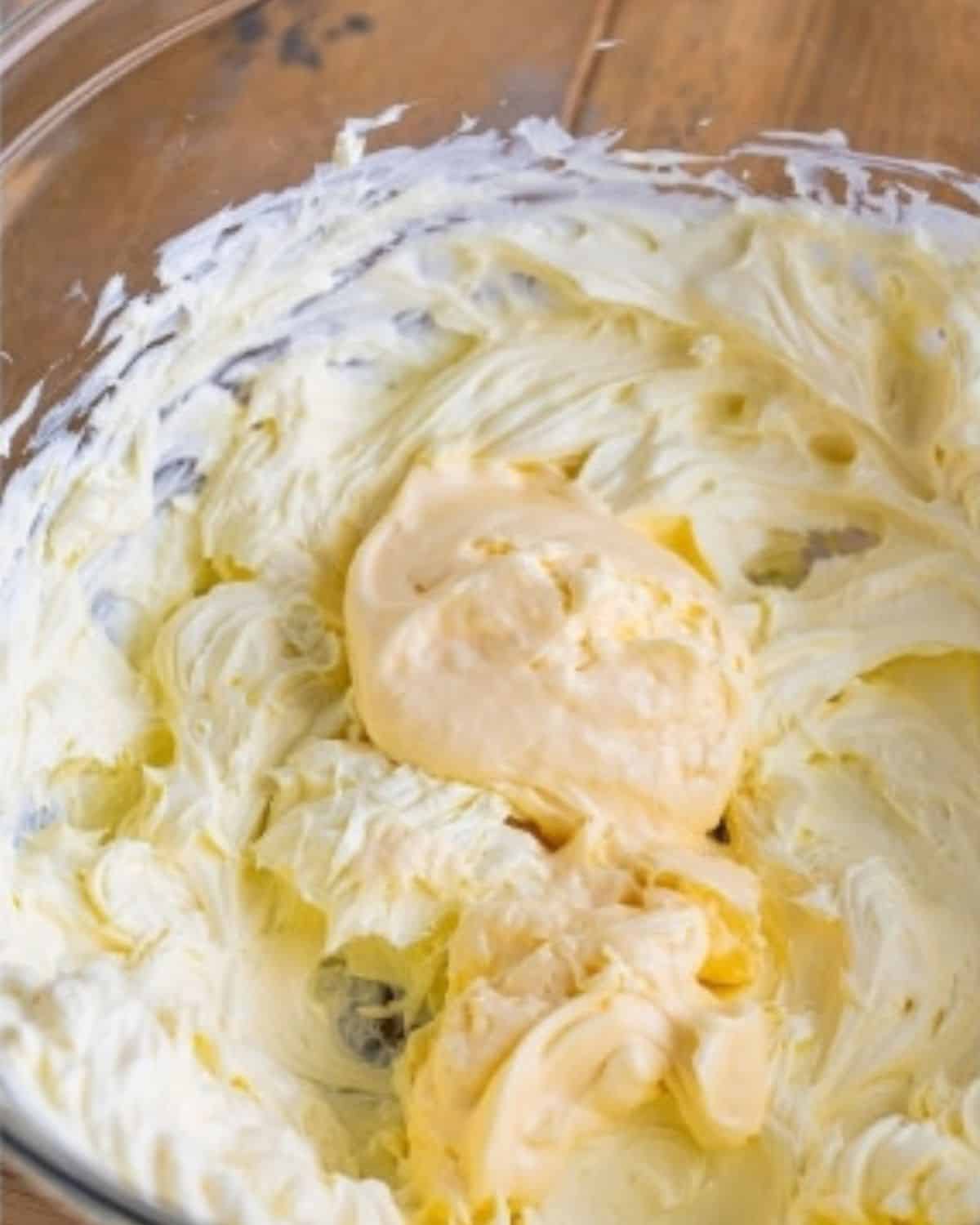 mayonnaise added in the bowl of whipped cream cheese.