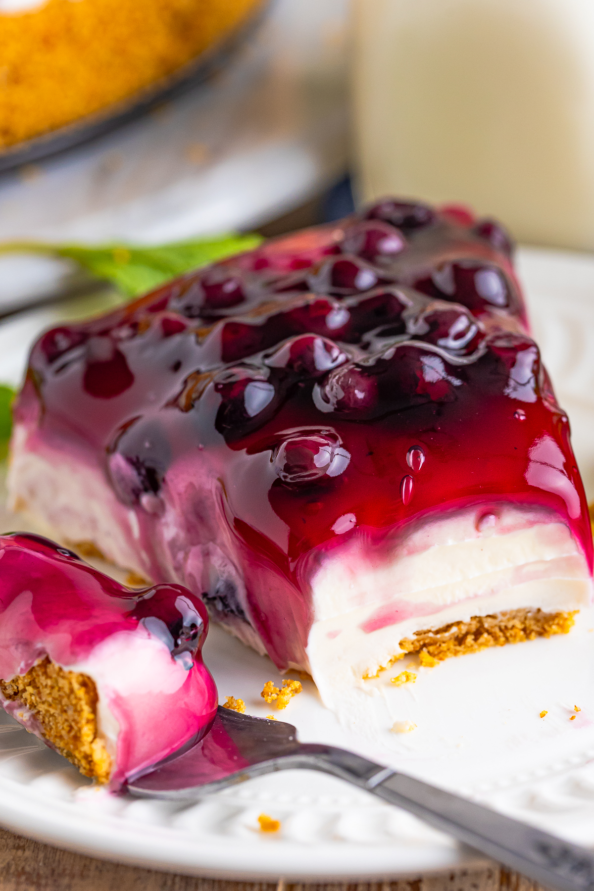 a slice of No Bake Cheesecake with Blueberries on a white plate with a bite taken out