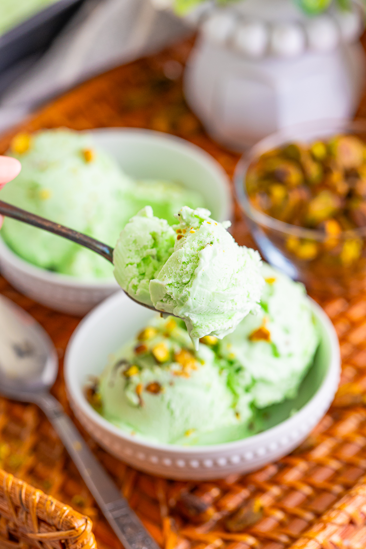 a spoon holding up a bite of Pistachio Ice Cream in air