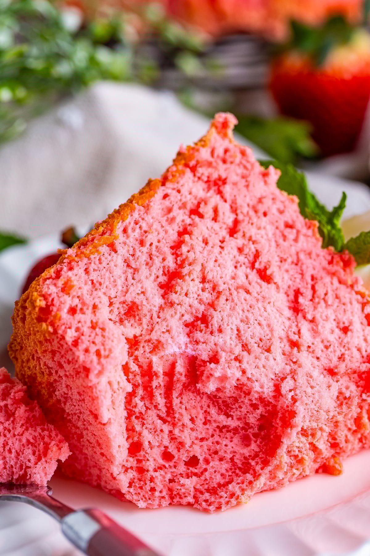up close image of Strawberry Angel Food Cake on a plate with a bite taken out