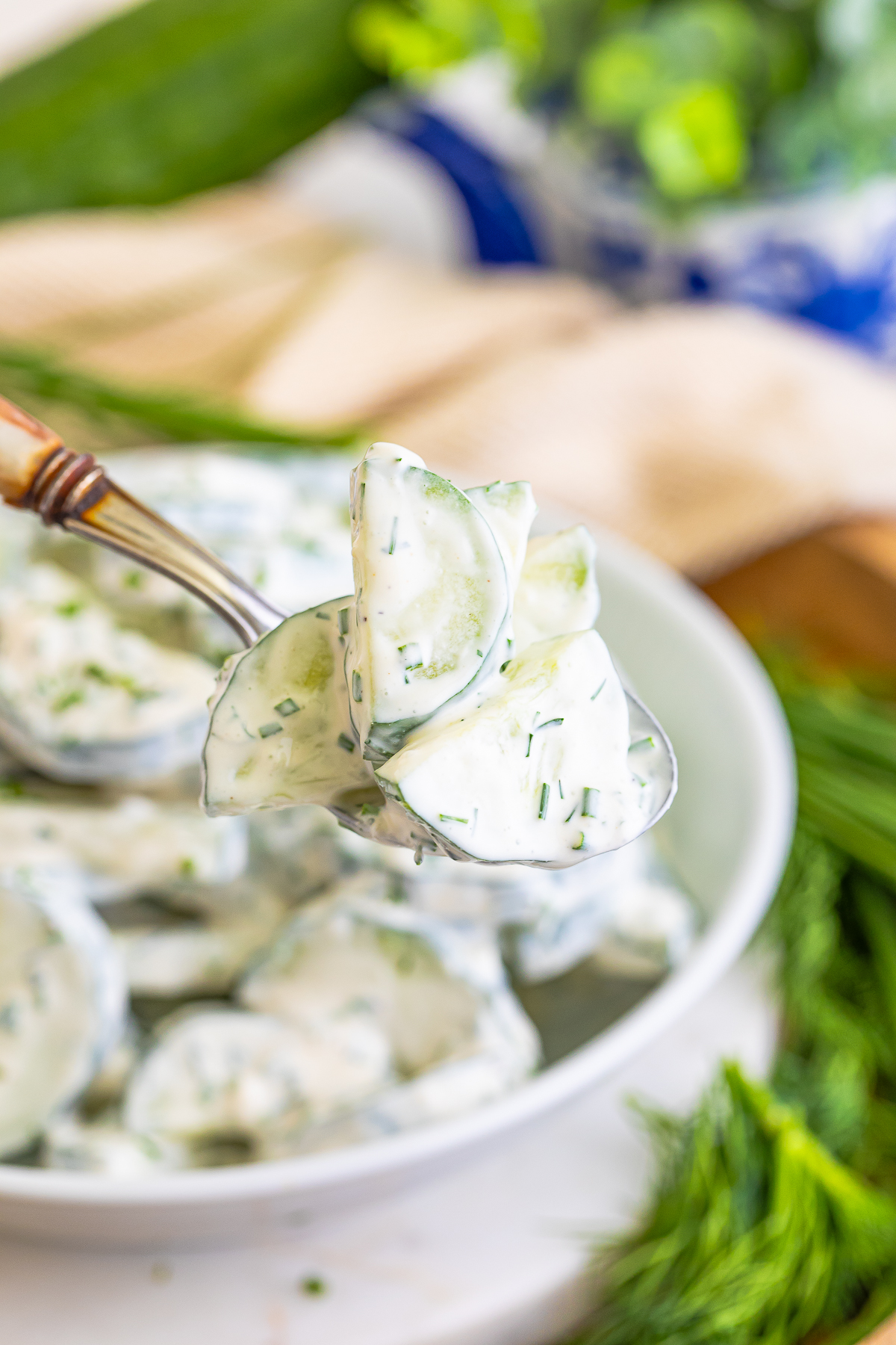 a bite of Cucumber Salad with Sour Cream on a spoon in air