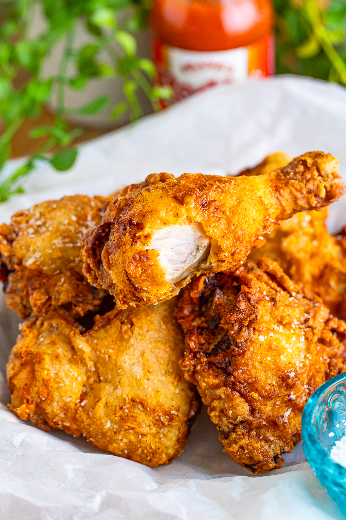 a piece of Louisiana Fried Chicken with a bite taken out on top of more chicken