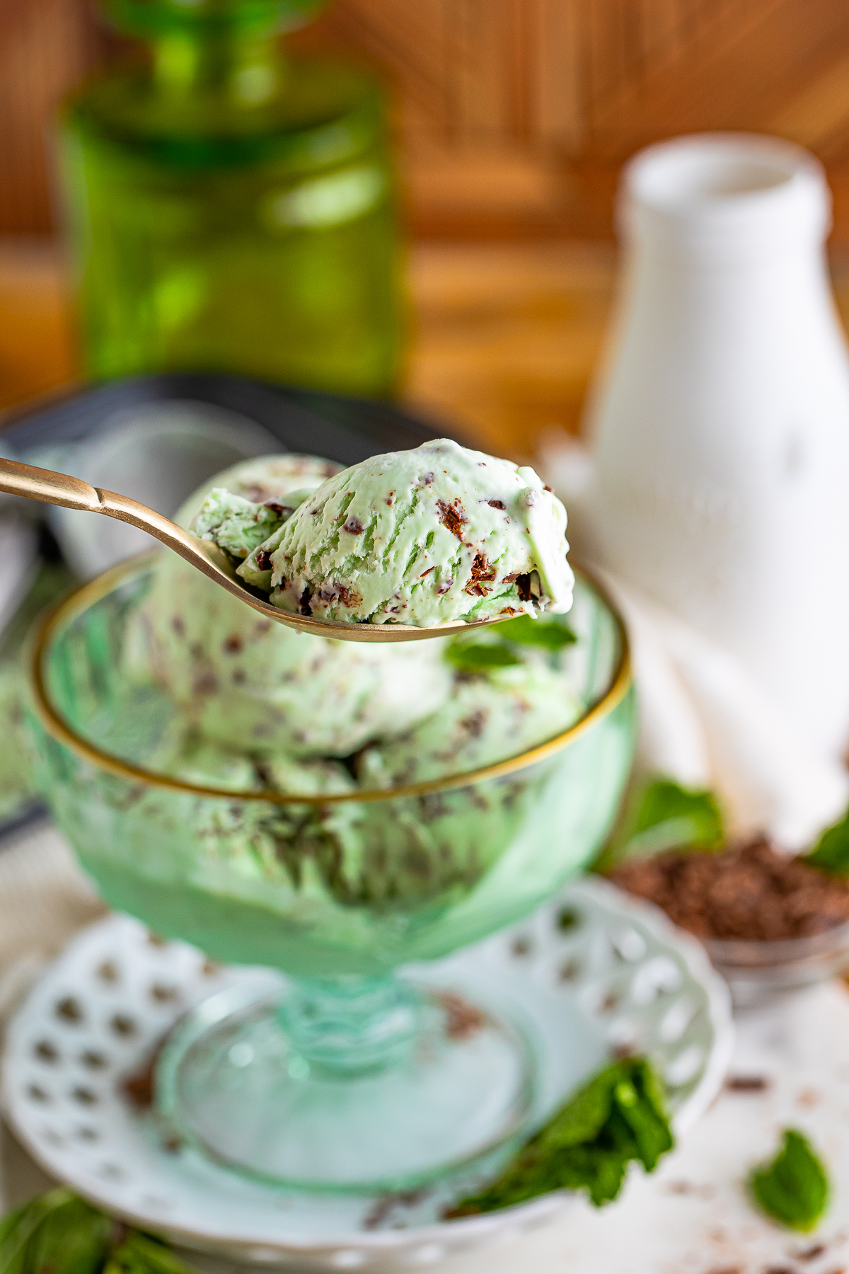 a spoon holding up a bite of mint chocolate chip ice cream in air