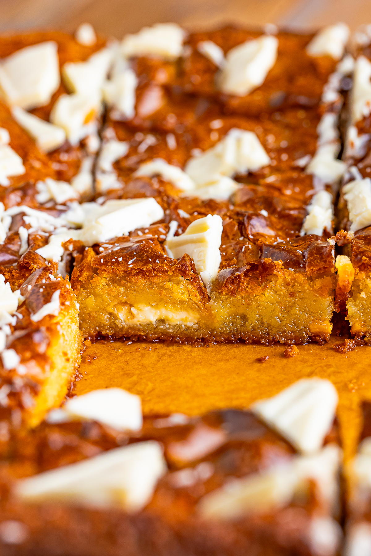 White Chocolate Brownies on parchment paper, cut to see the interior