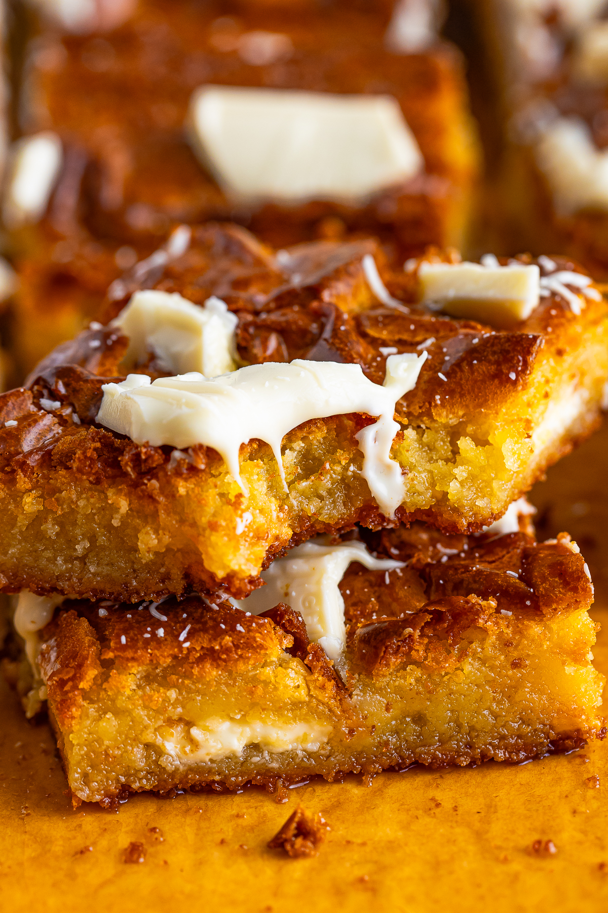 two White Chocolate Brownies stacked on top of each other, the one on top has a bite taken out