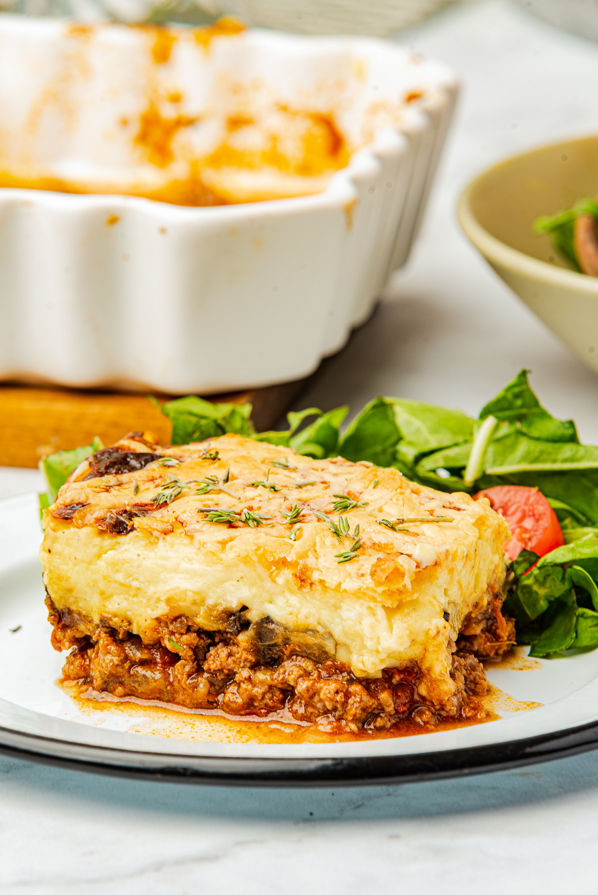 Close your eyes and picture a cozy kitchen on a hillside in Greece.

You can smell roasted eggplant slices, warm cinnamon, and a bubbly, creamy béchamel sauce turning golden under the oven light.

That, my friend, is Moussaka.