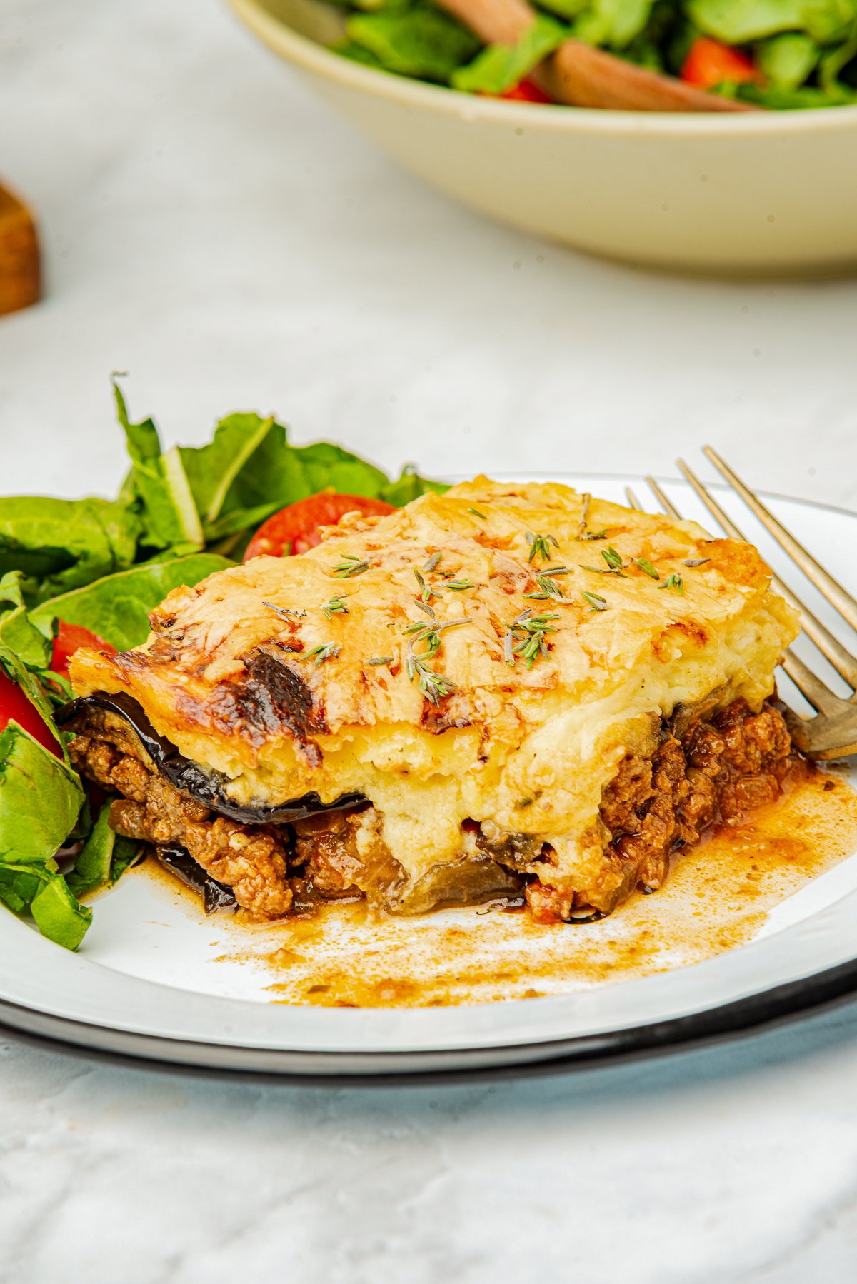 Close your eyes and picture a cozy kitchen on a hillside in Greece.

You can smell roasted eggplant slices, warm cinnamon, and a bubbly, creamy béchamel sauce turning golden under the oven light.

That, my friend, is Moussaka.