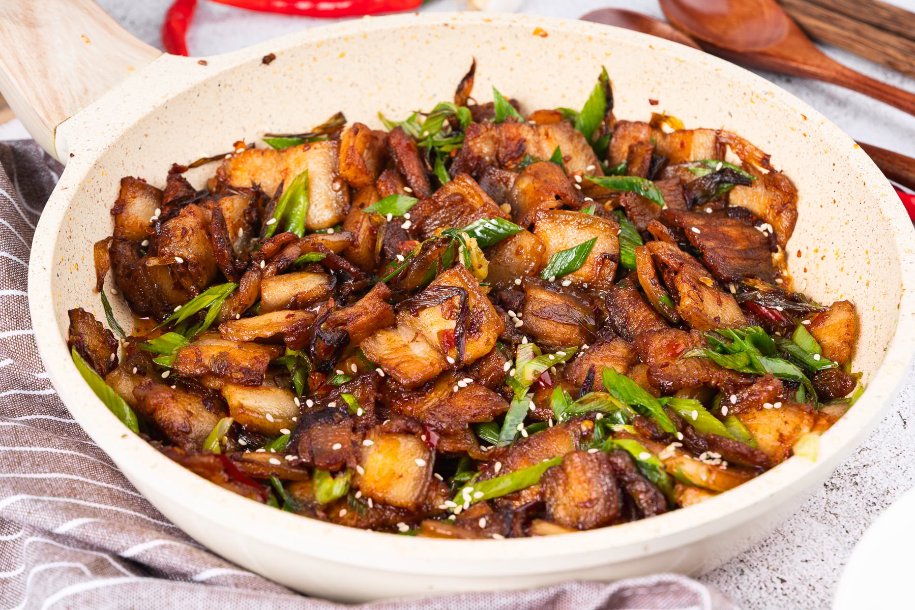 If you love bold flavors and quick dinners, Twice Cooked Pork might become your new best friend.

In China’s Sichuan Province, this dish is as famous as mapo tofu or red‑braised pork.

The Chinese name is hui guo rou, which means “returned‑to‑the‑wok pork.”

That’s because the pork belly really is Twice Cooked Pork, here: first it’s gently boiled, and then it’s hit with high heat in a sizzling stir fry!