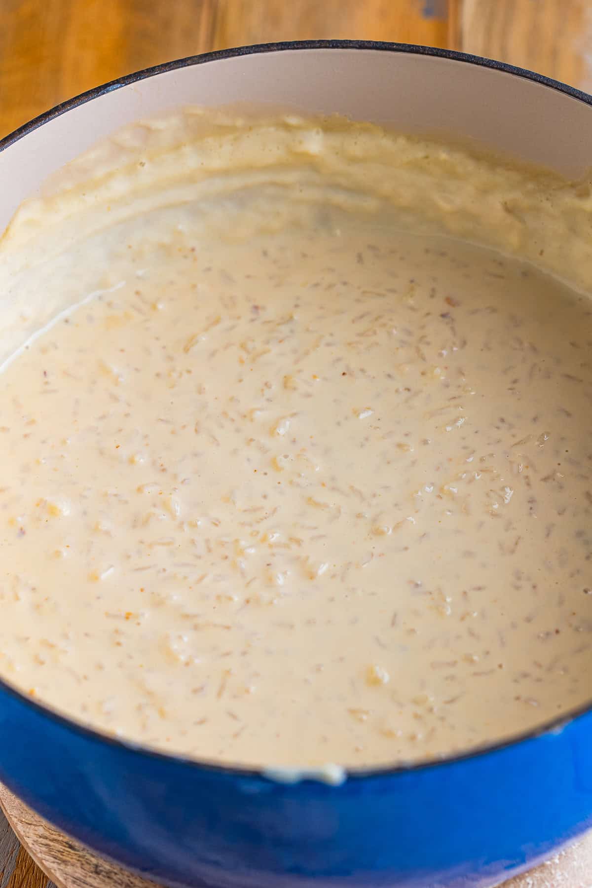 Finished thick and creamy Mexican Rice Pudding (Arroz Con Leche) in a large blue-rimmed pot ready to be served.