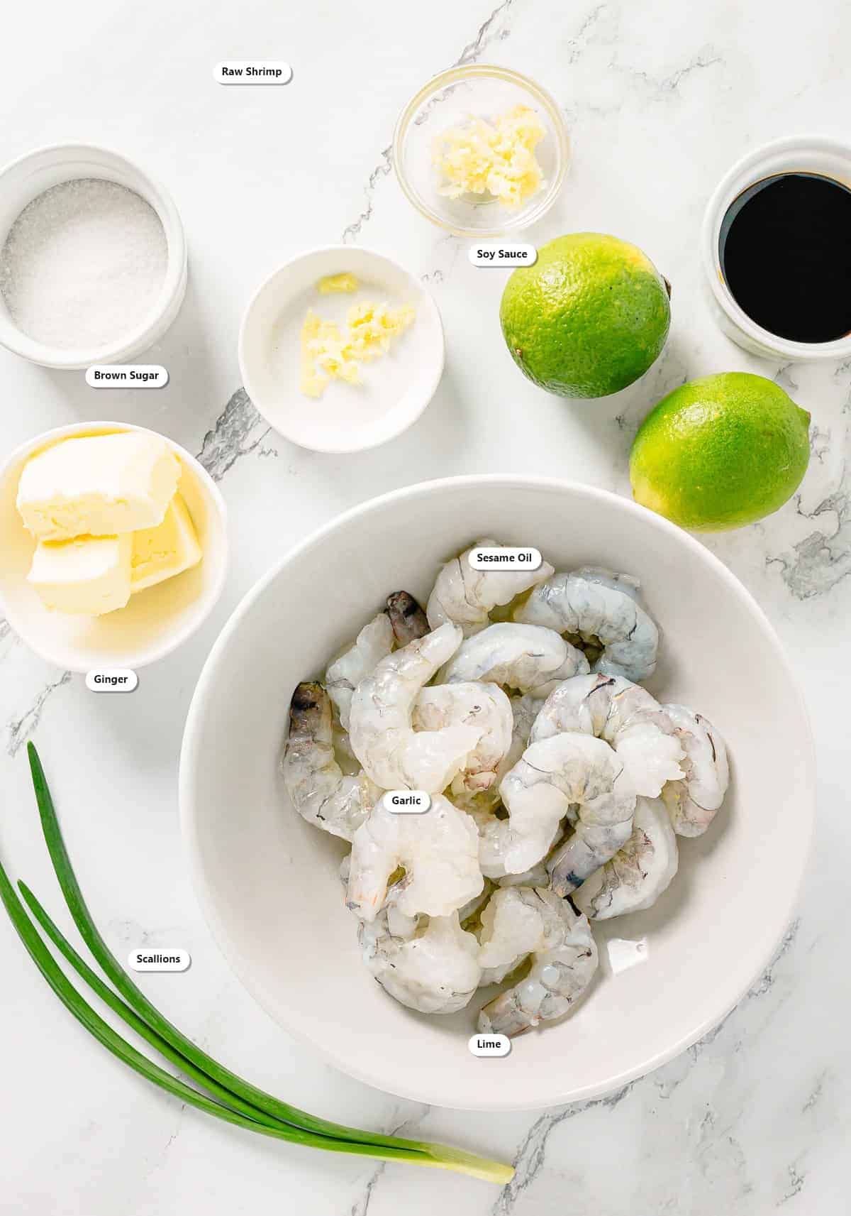 Labeled ingredients for Asian Marinated Grilled Shrimp Skewers including raw shrimp, soy sauce, brown sugar, sesame oil, ginger, garlic, scallions, and lime.