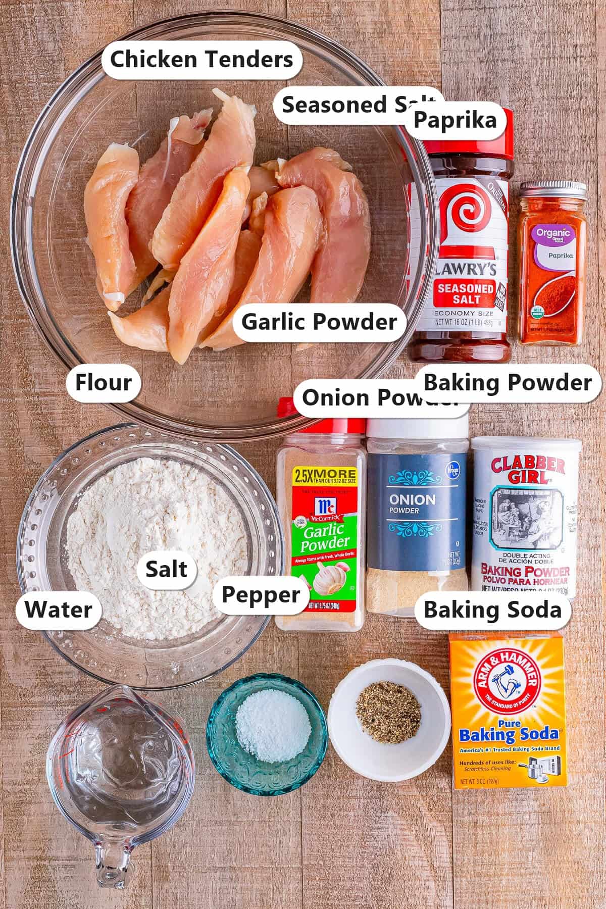 Labeled ingredients for The Best Crispy Fried Battered Chicken Tenders Recipe including chicken tenders, seasoned salt, paprika, flour, garlic powder, onion powder, baking powder, water, salt, pepper, and baking soda.